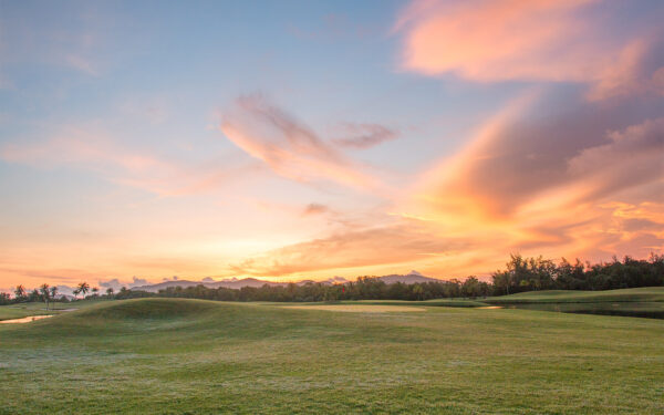 Golfer på Mission Hills golfbane under solnedgang i Phuket