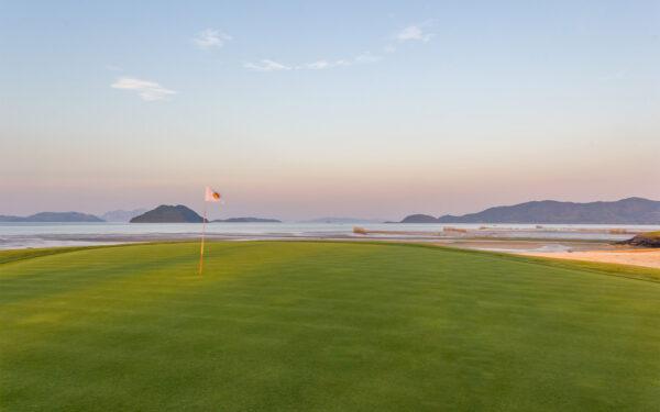 Mission Hills golfbane med flag midt i havet. Fantastisk golfoplevelse på øen omgivet af vand med perfekt manicurerede greens og