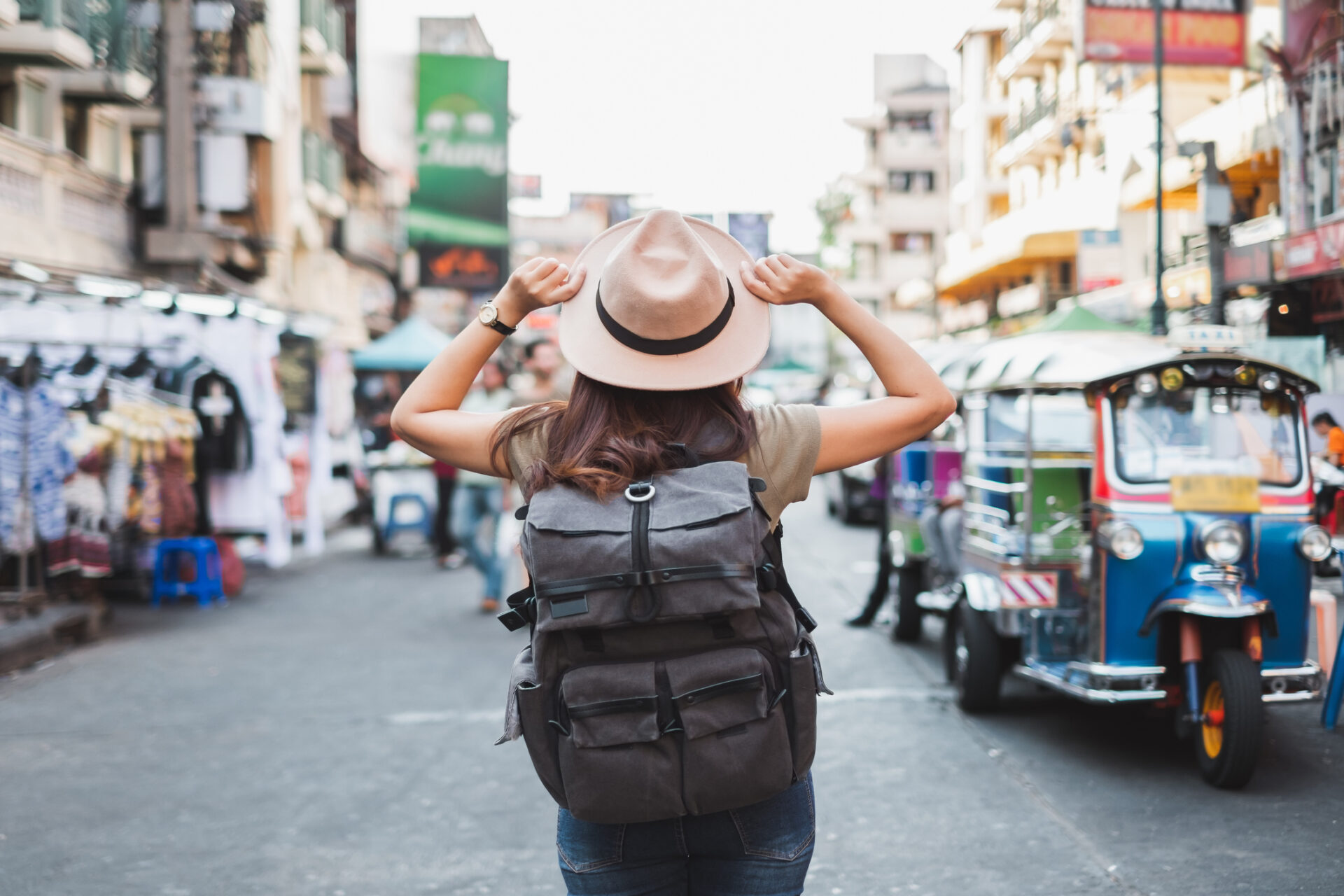 Kvinne med ryggsekk går nedover gaten i Bangkok, Thailand under Roundtrip